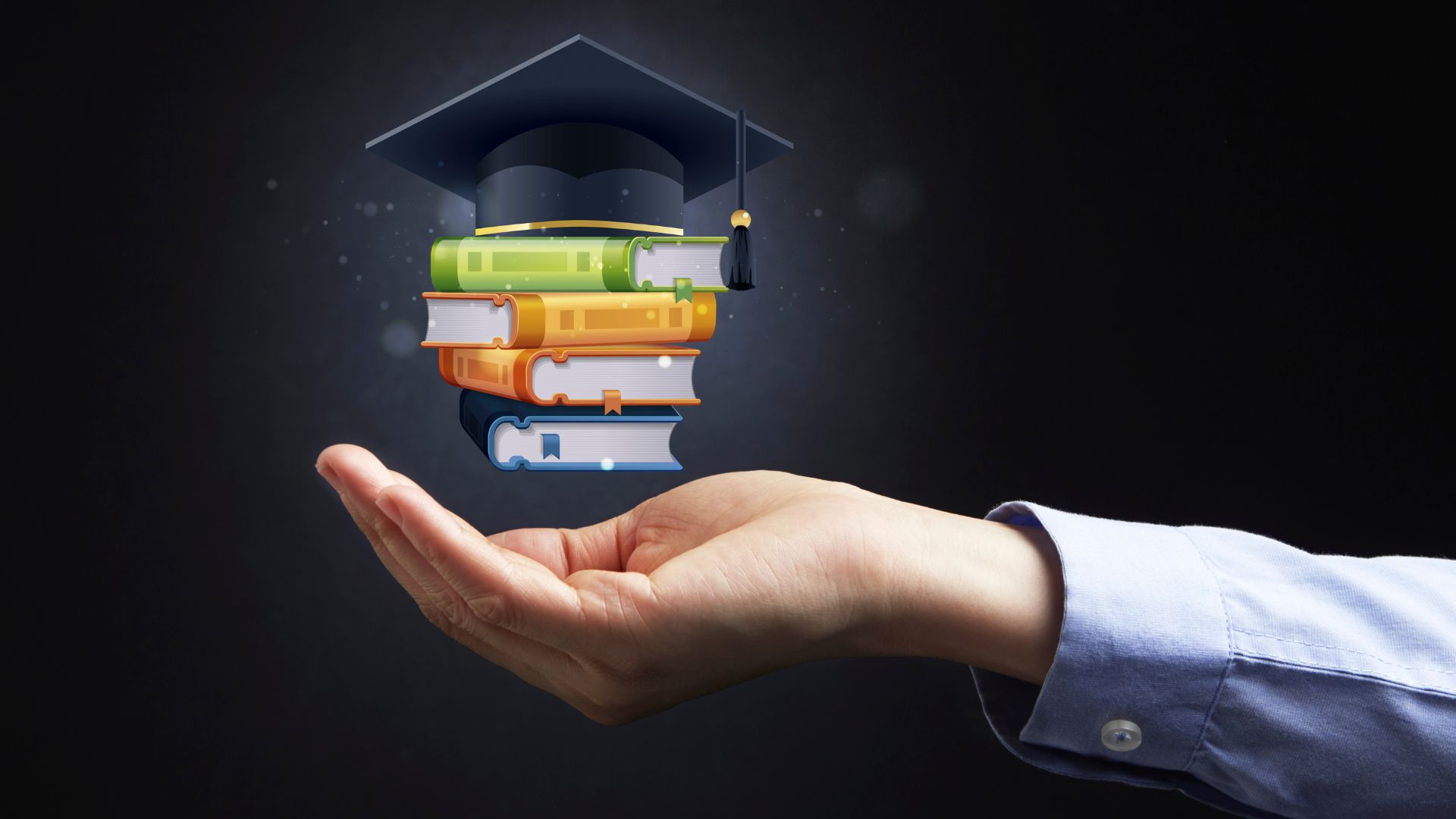 graduate reaching out his hand and in it, hovering above it, is cartoon digital image of a graduate cap and stack of school books